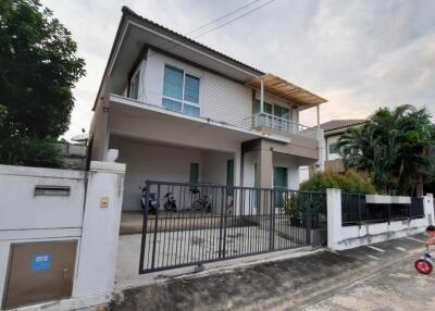 Exterior view of a modern two-story house with a child riding a bike in the foreground