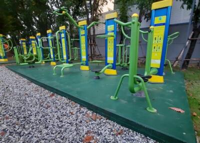 Outdoor gym with various exercise equipment in a green space