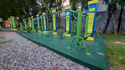 Outdoor gym with various exercise equipment in a green space