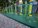 Outdoor gym with various exercise equipment in a green space