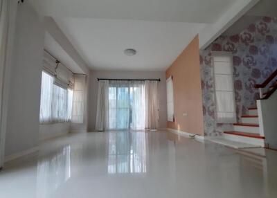 Spacious living room with large windows and staircase