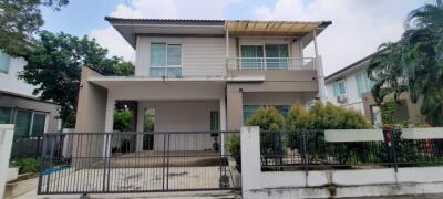 Front view of a modern two-story house with fenced yard