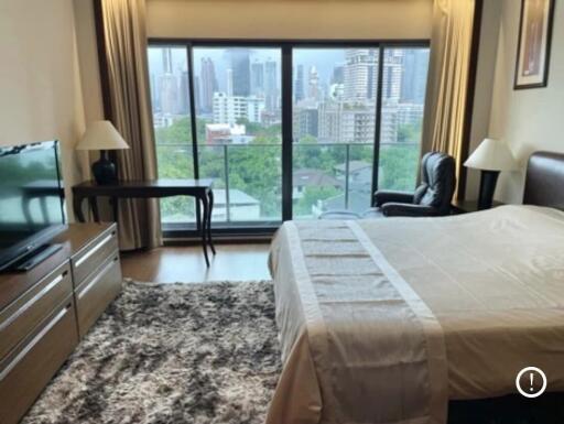 Bedroom with city view, TV, and cozy furnishings