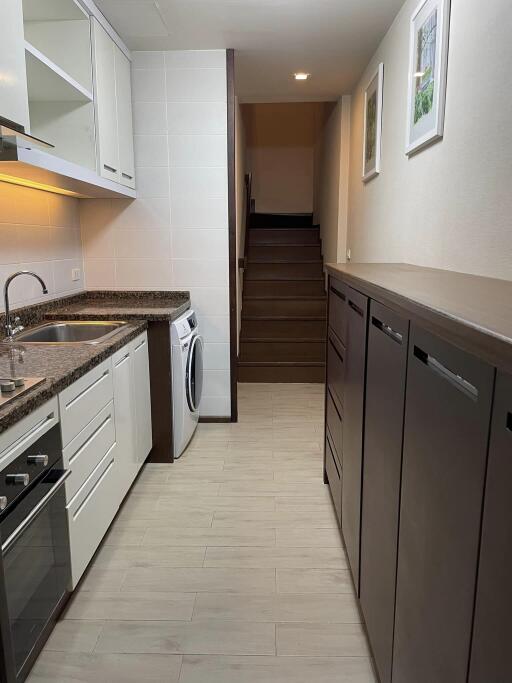 Modern kitchen with granite countertops and stairway