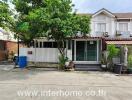 Front view of a townhouse with a small garden and driveway