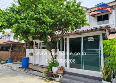 Exterior view of a house with glass entrance and lush greenery