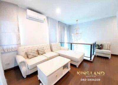 well-lit living room with white furniture and wooden floor