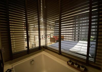 View of a bedroom through blinds with visible bed and decor