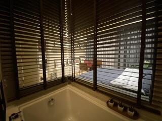 View of a bedroom through blinds with visible bed and decor