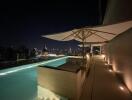 Rooftop pool with seating and city view at night