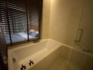 Modern bathroom with bathtub and window blinds