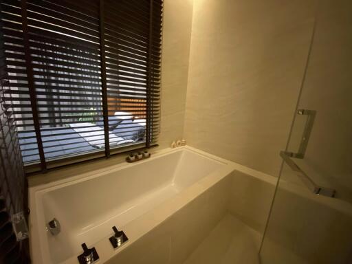 Modern bathroom with bathtub and window blinds