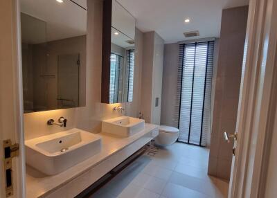 Modern bathroom with double sink, large mirrors, and glass-enclosed shower