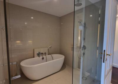 Modern bathroom with white standalone bathtub and glass-enclosed shower