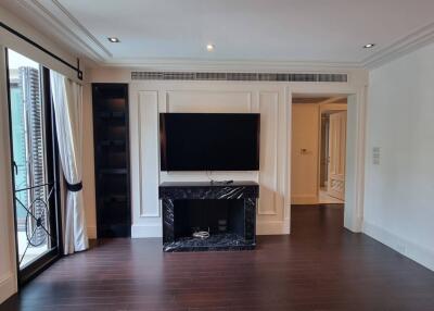 Living room with a wall-mounted TV and large window