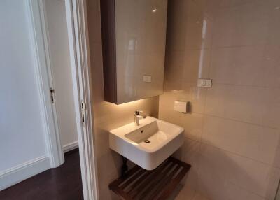 Modern bathroom with wall-mounted sink and ample lighting