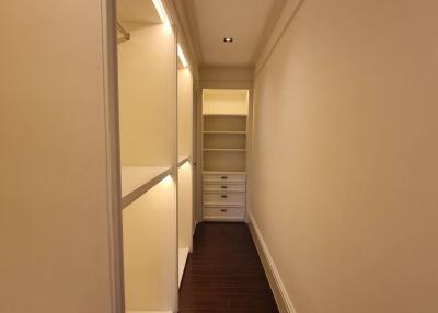 Well-lit, spacious walk-in closet with shelving and drawers