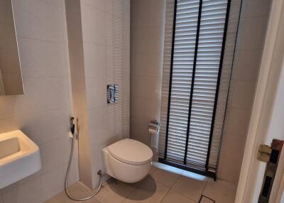 Modern bathroom with sink, toilet, and window with blinds