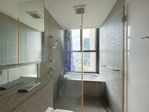 Modern bathroom with a bathtub and shower featuring city views through a large window