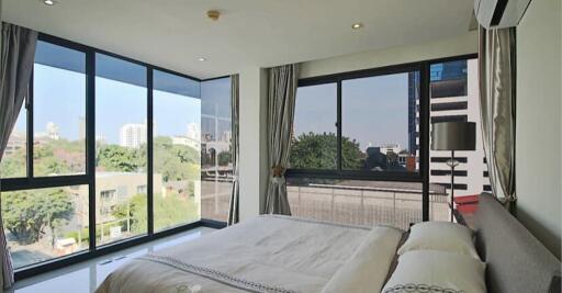 Modern bedroom with large windows and city view