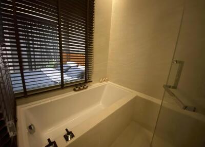 Modern bathroom with a bathtub and window blinds