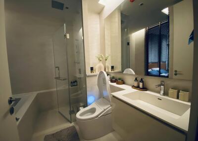 Modern bathroom with glass-enclosed shower, bathtub, and sleek vanity