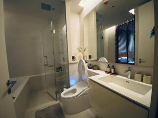 Modern bathroom with glass-enclosed shower, bathtub, and sleek vanity