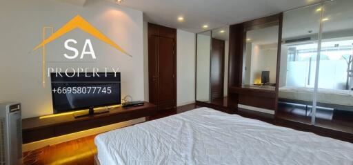 Spacious bedroom with wooden flooring and mirrored wardrobe