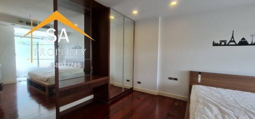 Modern bedroom with wooden flooring and built-in wardrobes