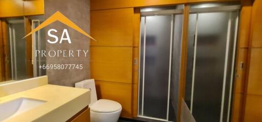 Modern bathroom with sink, toilet, and sliding glass shower doors