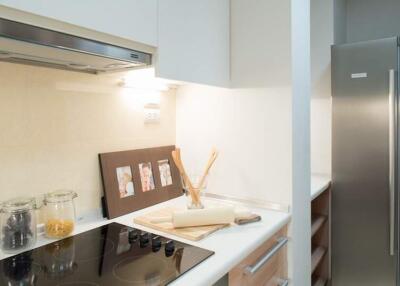 Modern kitchen with induction cooktop, stainless steel refrigerator, and elegant decor