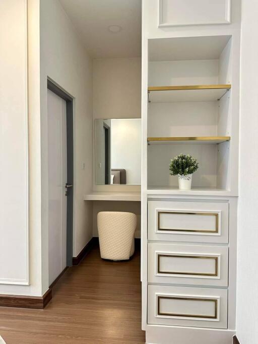 Bedroom with vanity, closed door, and elegant white decor