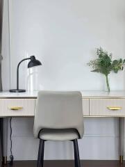 A modern home office desk setup with a lamp and a decorative plant