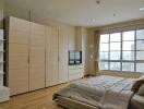 Spacious bedroom with a large window and ample storage