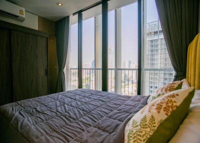 Bedroom with large windows and a city view