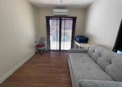 Modern living room with a sofa, chair, and air conditioning