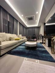 Modern living room with large sofa and decorative lighting