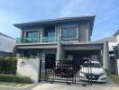 Two-story modern house with garage and cars