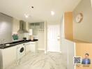 Modern kitchen with white cabinets and marble flooring