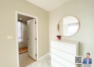 Bright bedroom corner with white dresser and round mirror