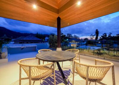 Outdoor patio area with a table and chairs at sunset