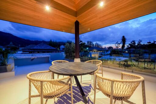 Outdoor patio area with a table and chairs at sunset