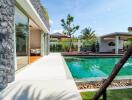 beautiful poolside view facing a modern building with large glass doors