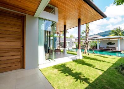 Modern house with wooden elements, lush garden, and pool