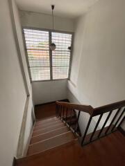 Staircase with wooden steps and large window