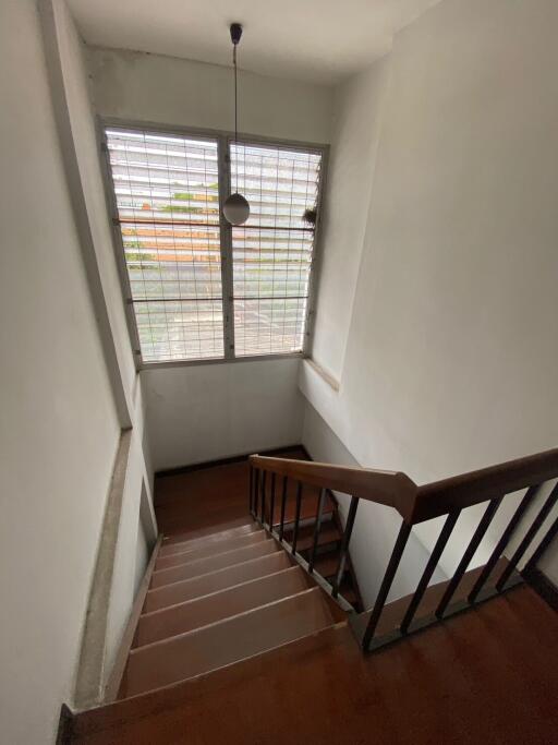 Staircase with wooden steps and large window