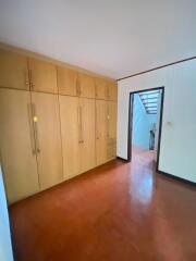 A spacious bedroom with built-in wooden wardrobes and a view of the stairway