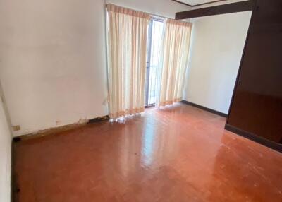 Empty living room with wooden floor and large window with curtains