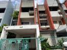 Front view of a multi-story residential building with a gated entrance