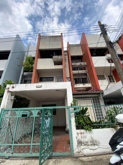 Front view of a multi-story residential building with a gated entrance